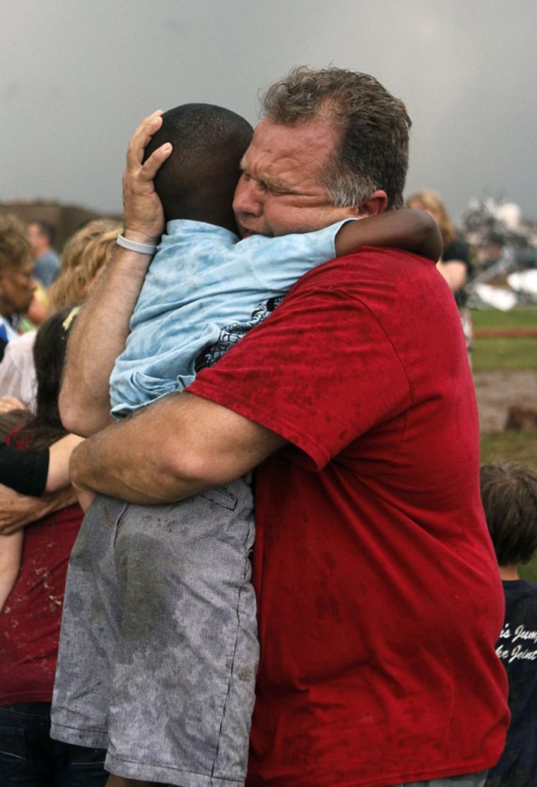 A teacher hugs a child at Briarwood Elementary school after a tornado destroyed the school in south Oklahoma City.