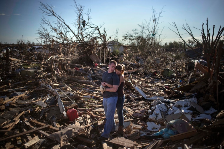 Image: Danielle Stephan holds boyfriend Thomas Layton as they pause between salvaging through the remains of a family member's home one day after a tornado devastated the town Moore, Oklahoma