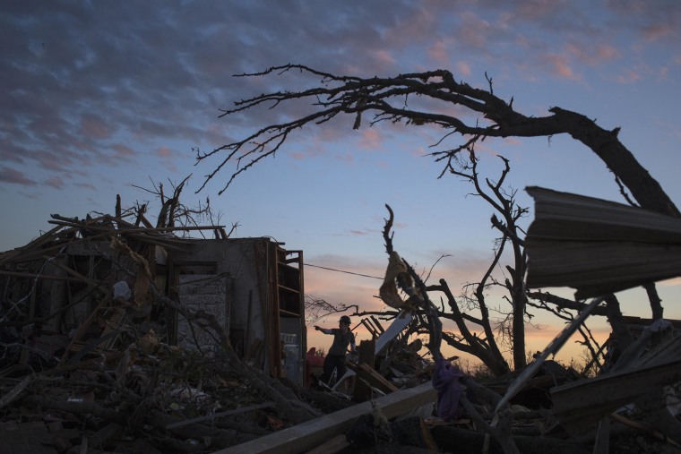 Image: A woman searches for possessions at sunset after the suburb of Moore, Oklahoma was left devastated by a tornado