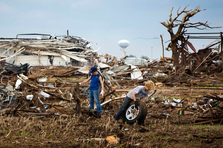 Image: Two boys work to remove debris from a field near the Orr Family Farm in Oklahoma City