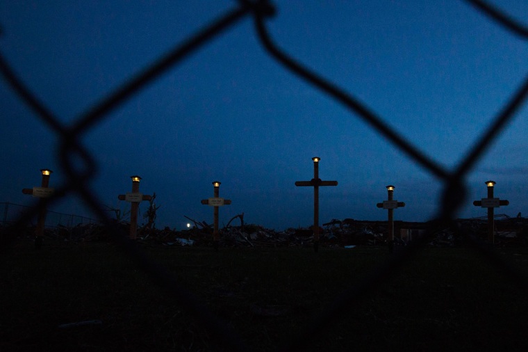 Image: Lights shine on the tops of crosses making up a memorial outside the Plaza Towers elementary school where seven children died and several students and teachers were injured by the May 20 afternoon tornado in Moore, Oklahoma