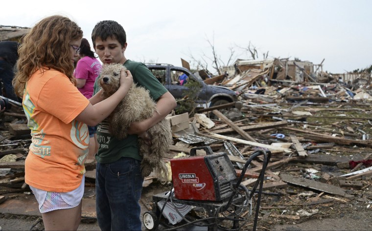 Image: Abby Madi and Peterson Zatterlee comforts Zaterlee's dog Rippy, after a tornado struck Moore, Oklahoma