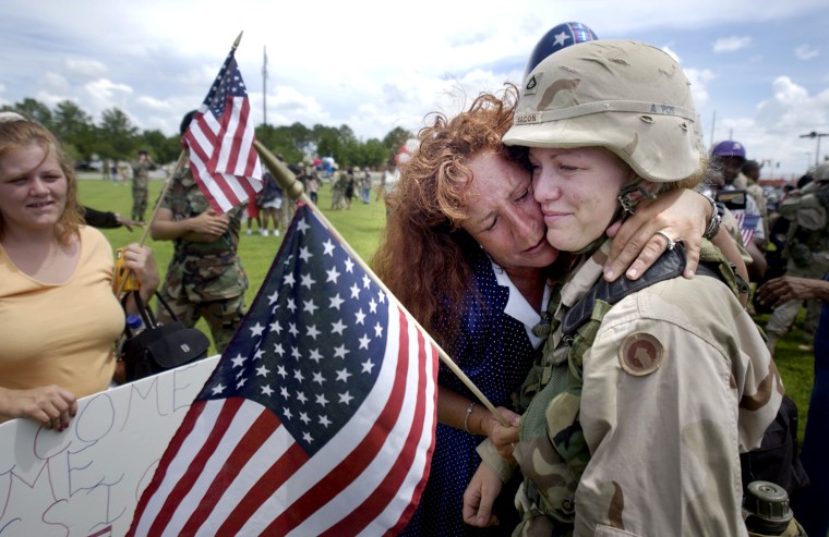 FT. STEWART GA-JULY 6: Sharing an emotional moment with her daughter, Michelle Dirksen, center, hugs her daughter U.S. Army Pfc. Jessica Bacon Sunday July 6, 2003 at Ft. Stewart, Ga. after she returned home from Iraq with the 24th Corps Support Group. The 24th Corps Support Group which provides general combat service support to units of the 3rd Infantry Division. Carole Bell, left, came to support her friend's homecoming. About 300 soldiers arrived Sunday, making this the largest homecoming at Fort Stewart since the 3rd Infantry began deploying 16,500 soldiers to the Persian Gulf late last year.(Photo by Stephen Morton/Getty Images)