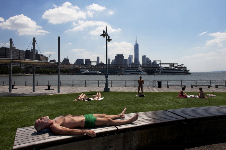 Image: A man sunbathes during a heat wave in New York City on Tues.