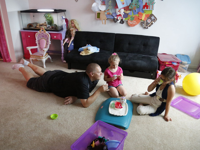 Carl Poff attends a tea party with his two daughters Joselyn and Jillian in their playroom at the home in Easton, Pa., on Thursday, June 14, 2013.