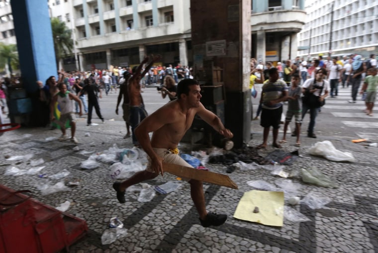 Image: A demonstrator chases vandals during a protest against the Confederations Cup and the government of Brazil's President Dilma Rousseff in Recife City