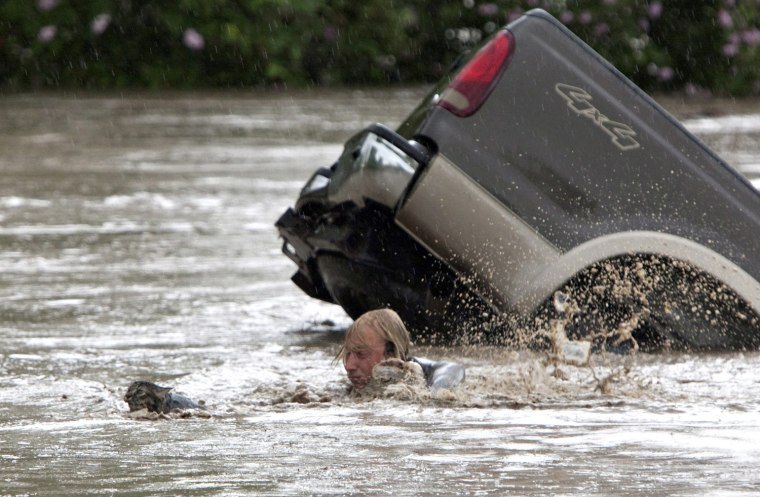 Image: Kevan Yaets swims after his cat Momo as floodwaters sweep him downstream and submerge his truck in High River, Alberta.