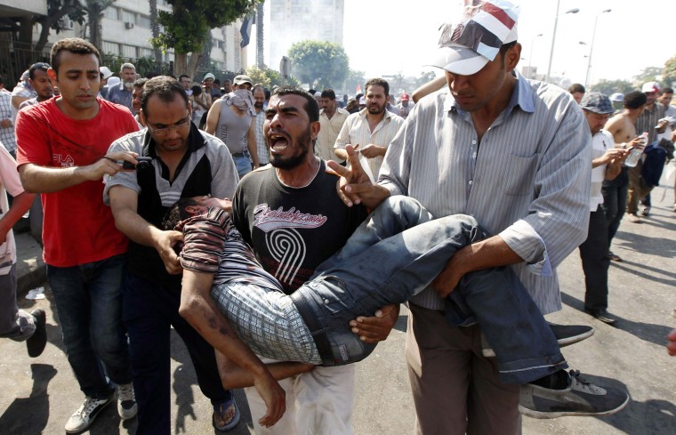 Image: Protesters who support former Egyptian President Mohamed Mursi carry an injured man during clashes outside the Republican Guard building in Cairo