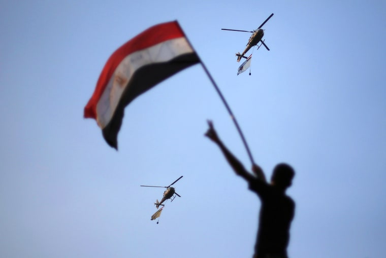 Image: Egyptian military helicopters trailing national flags circled over Tahrir Square during a protest demanding that Egyptian President Mohamed Mursi resign in Cairo