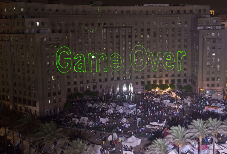Image: Egyptian protesters calling for the ouster of President Mohamed Morsi gather in Cairo's landmark Tahrir Squar as laser lights directed at the government building spell \"Game Over.\"