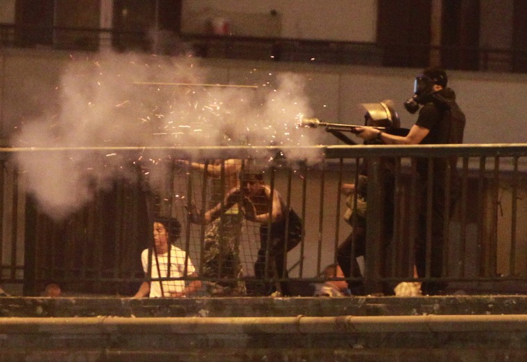 Image: Riot policemen fire tear gas towards supporters of deposed Egyptian President Mohamed Mursi on the Sixth of October Bridge over the Ramsis square area in central Cairo