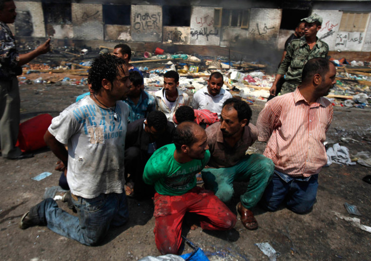 Image: Suspects are rounded up near a burnt annex building at the Rabaa Adawiya mosque in Cairo