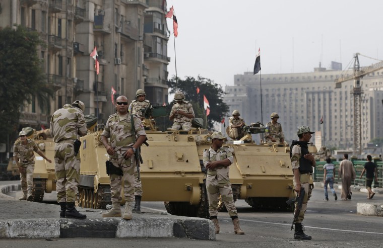 Image: Egyptian army soldiers stand beside armored vehicles while guarding an entrance of Tahrir square.