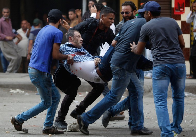 Image: Protesters who support ousted Egyptian President Mohamed Mursi carry an injured demonstrator during clashes at Ramses Square in Cairo