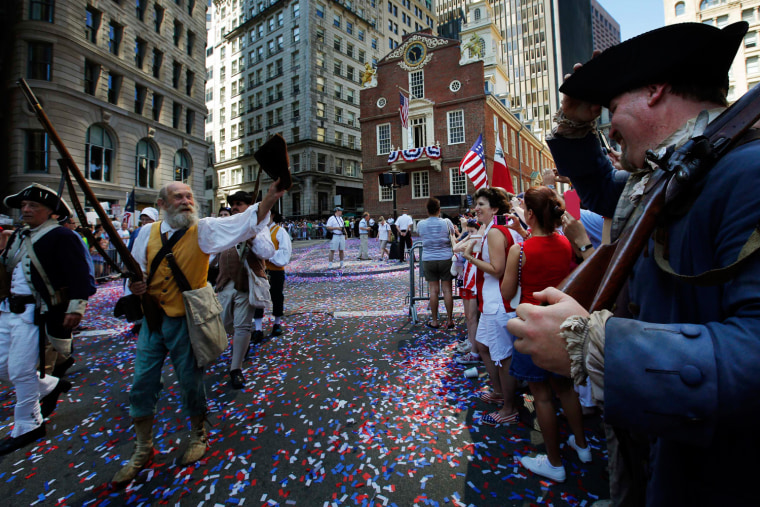 Image: Re-enactors march away from the Old State House following a public reading of the United States Declaration of Independence, part of July Fourth Independence Day celebrations, in Boston
