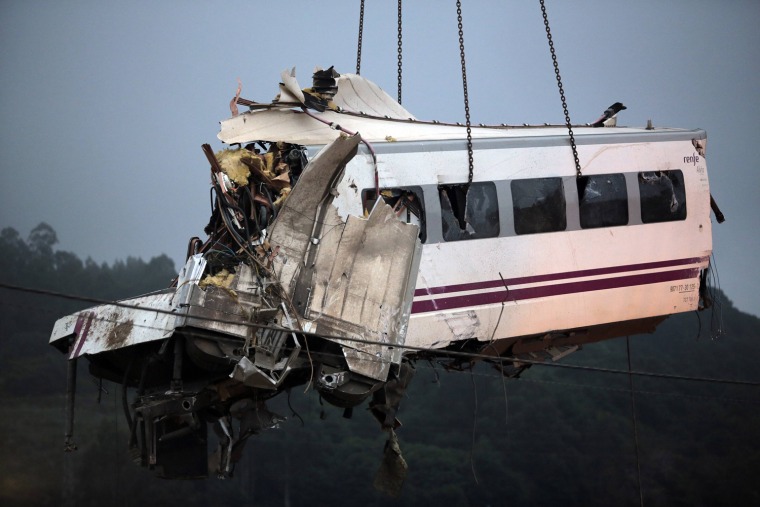 Image: A crane removes a carriage from the tracks at the site of a train crash near Santiago de Compostela