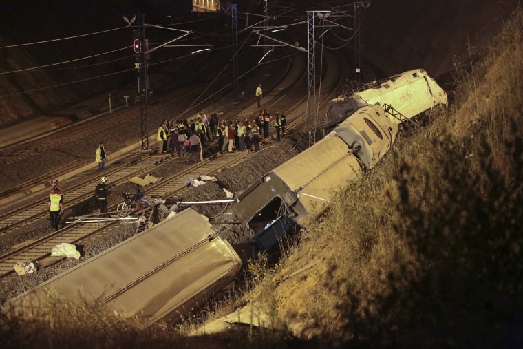 Image: Rescue workers and officials are seen amongst the wreckage of a train crash near Santiago de Compostela