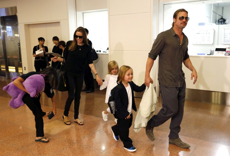 Image: Hollywood actors Brad Pitt and actress Angelina Jolie arrive with their children at Haneda international airport in Tokyo