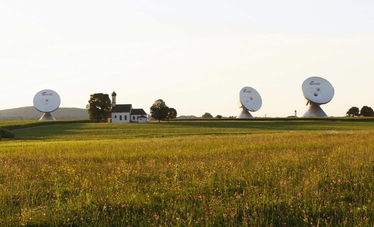 Image: Protected satellite earth station dishes surround a church in Raisting