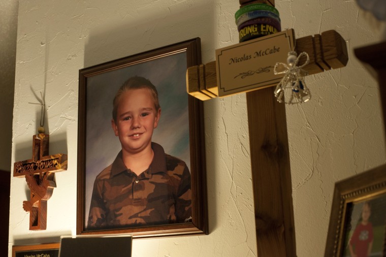 Image:  A photograph of Nicolas McCabe, 8, hangs in the living room amidst memorial crosses at the McCabe home in Moore, OK