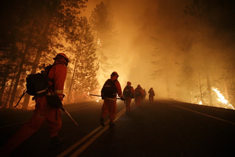 Image: Inmate firefighters walk along state Highway 120 as firefighters continue to battle the Rim Fire near Yosemite National Park, Calif.