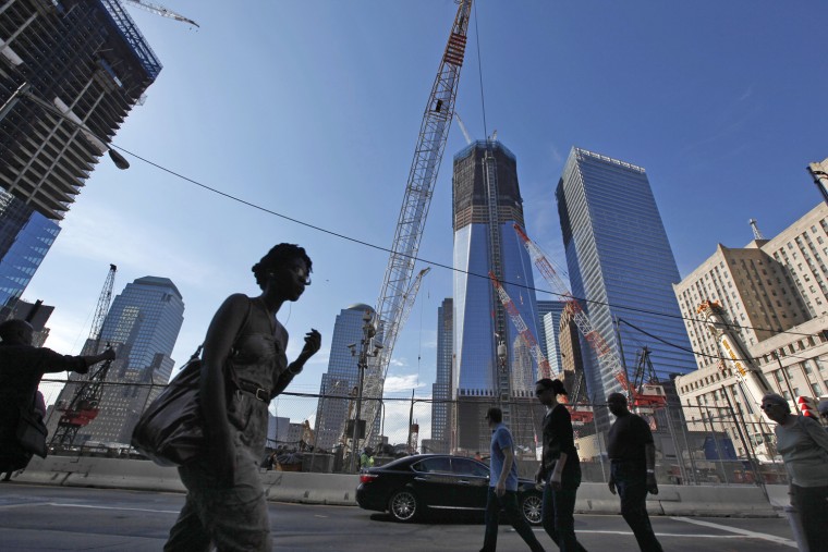 Image: People walk past the construction site of the World Trade Center in New York
