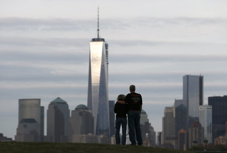 Image: A couple look out at New York's Lower Manhattan and One World Trade Center from Liberty State Park in Jersey City