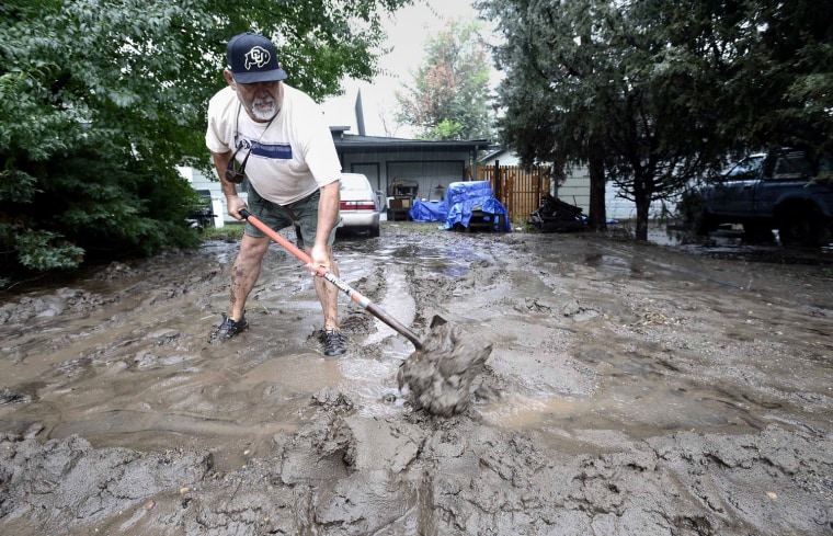 Image: Rich Luna tries to make a mud barrier in front of his house near 19th and Violet as heavy rains cause flooding in Boulder Colorado