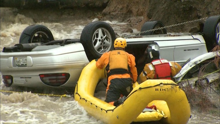 Image: Emergency personnel rescue a man trapped in his vehicle in Colorado
