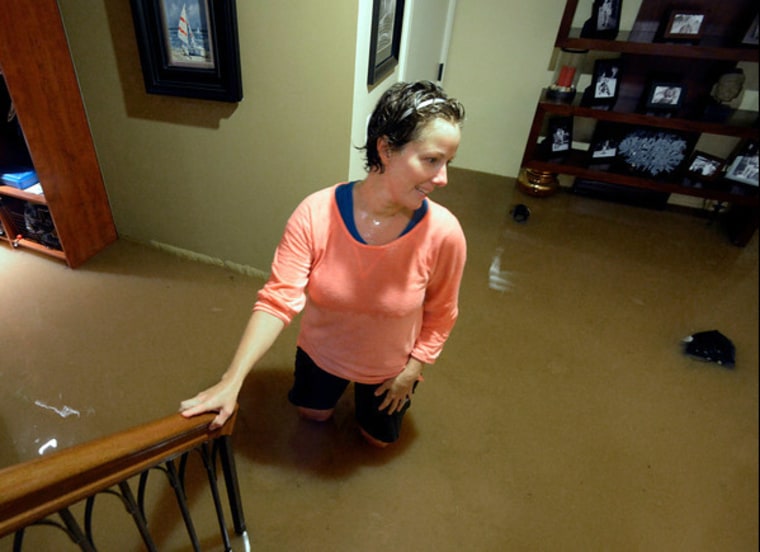 Britt Drake, of Boulder, stands in her flooded basement during the heavy flooding on Thursday, Sept. 12, in Boulder, Colo.