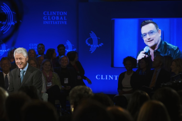 Image: Former U.S. President Clinton watches artist Bono do an impression of him during the Clinton Global Initiative in New York