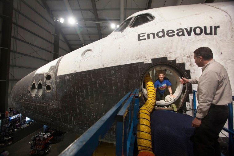 Image: Oschin is helped out of the space shuttle Endeavour after a tour with CSC president Rudolph in Los Angeles