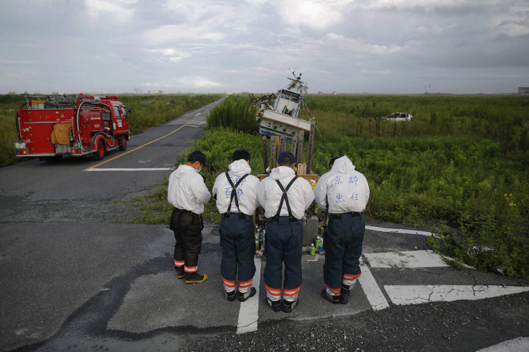 Image: Firefighters from Kyoto pay respect to victims as they visit the tsunami destroyed coastal area of the evacuated town of Namie