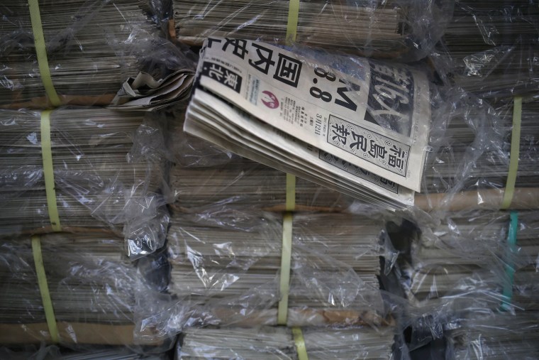 Image: Copies of Fukushima Minpo newspapers with headlines \"M(magnitude) 8.8, largest in the country\" and dated a day after the devastating 2011 earthquake are seen inside the office in the evacuated town of Namie in Fukushima prefecture