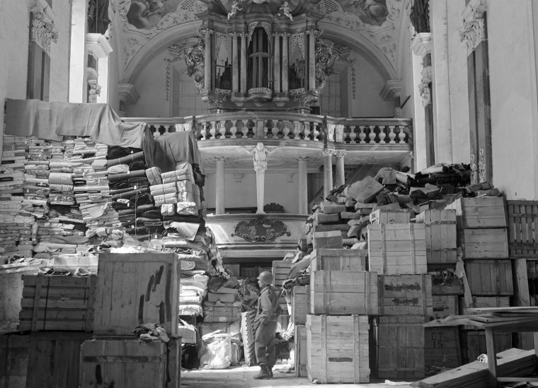 In this April 24, 1945 photo released by the U.S. National Archives, an American soldier stands among German loot stored in a church at Elligen, Germany. Holocaust survivors and their relatives, as well as art collectors and museums, can go online beginning Monday, Oct. 18, 2010 to search a historical database of more than 20,000 art objects stolen in German-occupied France and Belgium from 1940 to 1944. (AP Photo/U.S. National Archives)