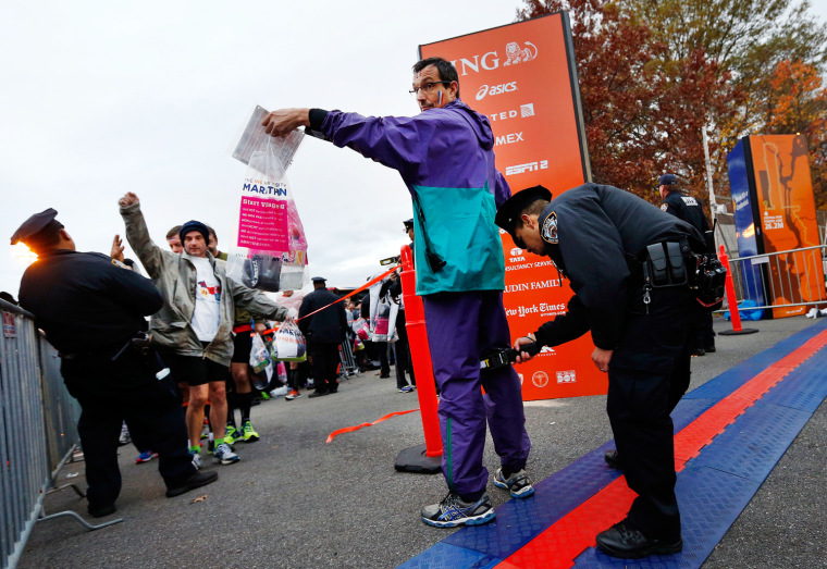 Image: Runners are screened by police officers as they arrive for the New York City Marathon
