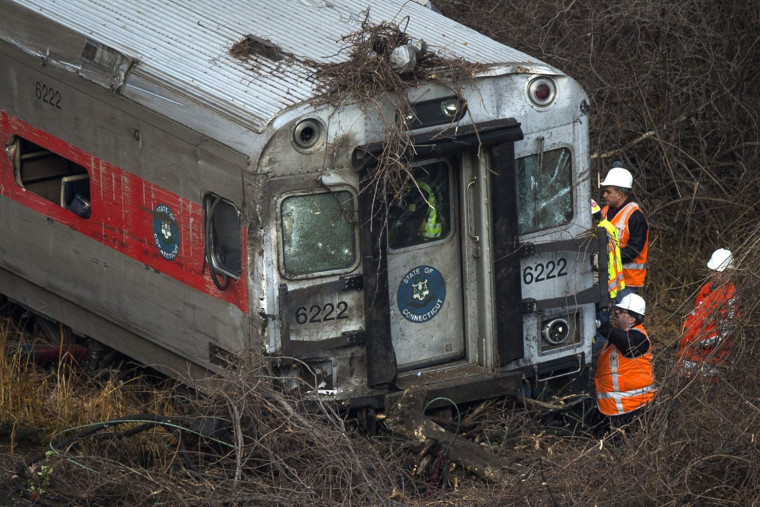 Image: Rescue workers search through a car at the site of a Metro-North train derailment in the Bronx borough of New York