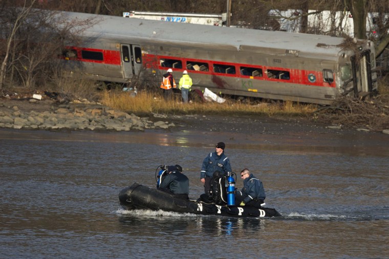 Image: New York Police Department officials use a boat to search the waters around the site of a Metro-North train derailment in the Bronx borough of New York