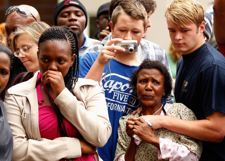 Image: People comfort each other outside the residence of former South African President Nelson Mandela in Johannesburg