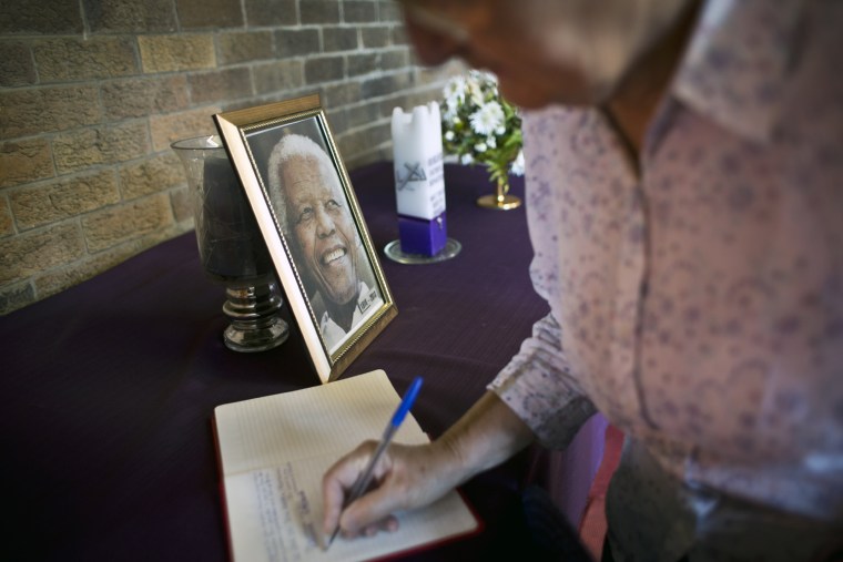 Image: A mourner signs the book of condolences at the iconic Regina Mundi church, which became one of the focal points of the anti-apartheid struggle, in Soweto, Johannesburg, on Dec. 7.
