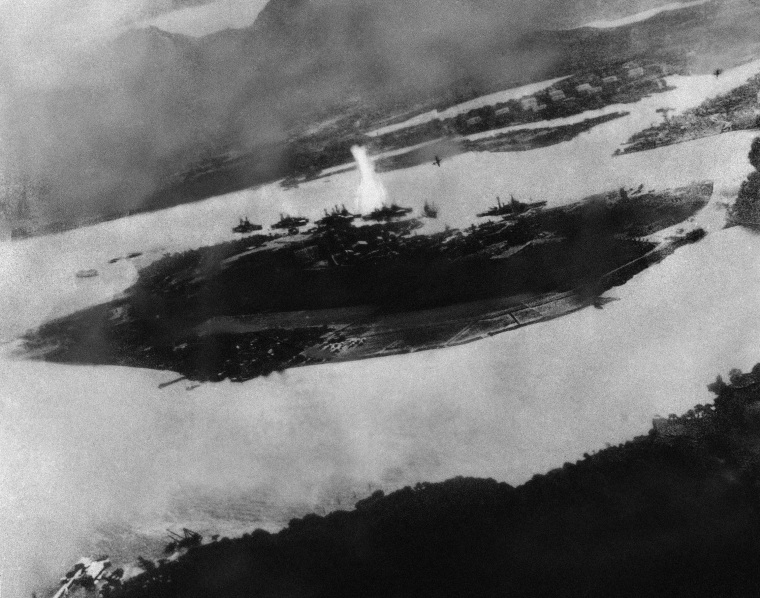 Believed to be the first bomb dropped on Pearl Harbor, Hawaii in the sneak-attack on Dec. 7, 1941, this picture was found torn to pieces at Yokusuka Base by photographer's mate 2/C Martin J. Shemanski of Plymouth, Pa. One Japanese plane is shown pulling out of a dive near bomb eruption (center) and another the air at upper right. (AP Photo)