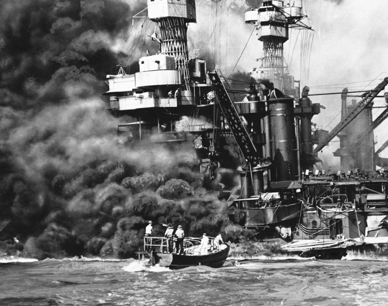 In this photo provided by the U.S. Navy, a Navy launch pulls up to the blazing USS West Virginia to rescue a sailor, Dec. 7, 1941, during the attack on Pearl Harbor (AP Photo/U.S. Navy)