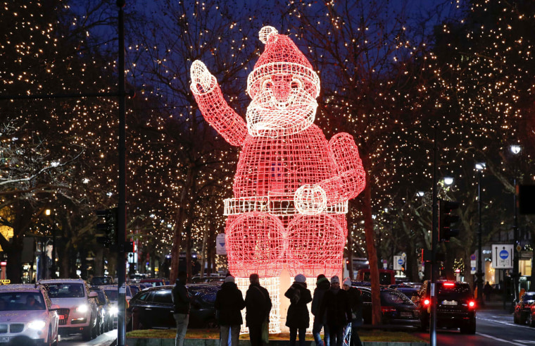 Image: A Santa Claus figure is illuminated at the main shopping mall Kurfuerstendamm boulevard as part of its Christmas illumination in Berlin