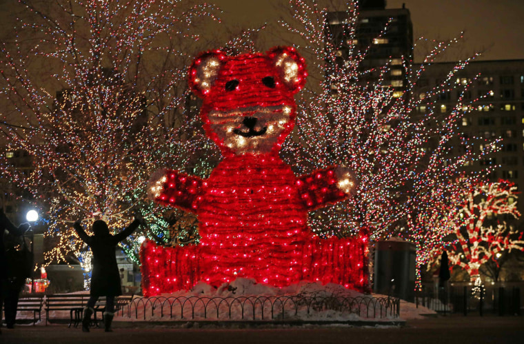 Image: A visitor reacts while looking at a giant teddy bear creation at holiday lights showcase \"ZooLights\" at the Lincoln Park Zoo in Chicago