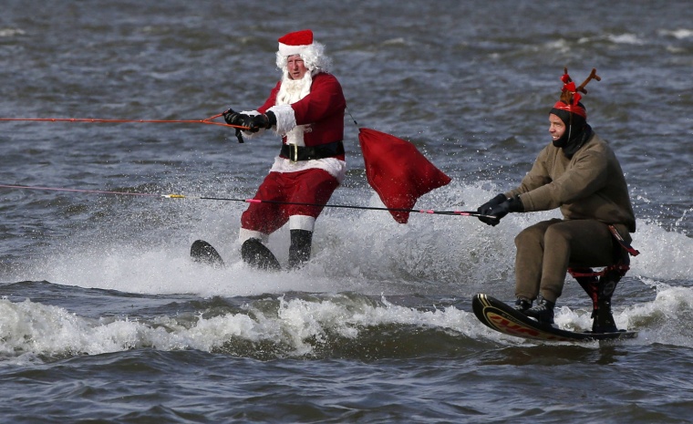 Image: A water skier dressed as Santa is joined by a man dressed as a reindeer as they ski in the Potomac River at National Harbor to celebrate Christmas Eve in Maryland