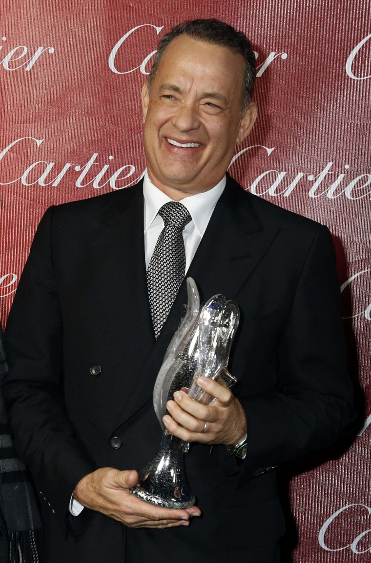 Image: Actor Tom Hanks, star of the films \"Captain Phillips\" and \"Saving Mr. Banks\" poses backstage with the Chairman's Award at the 2014 Palm Springs International Film Festival Awards Gala