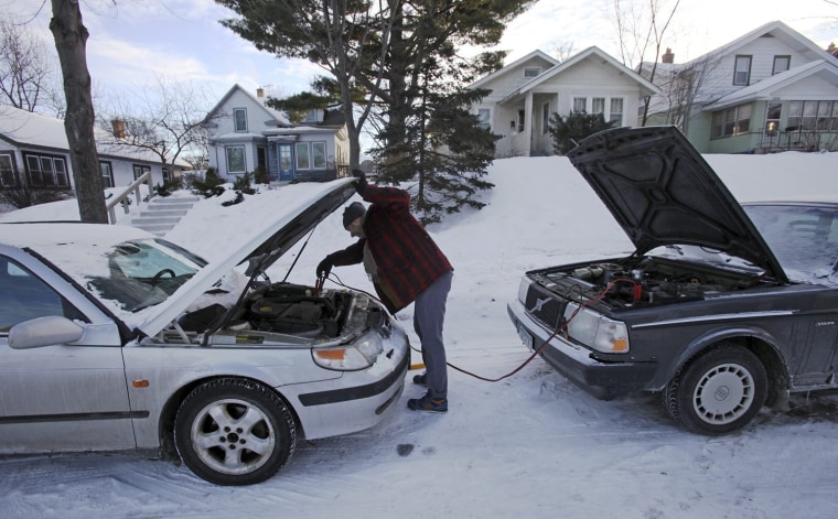 Image: James Diers unhooks jumper cables after he was unable to jump start his car in Minneapolis