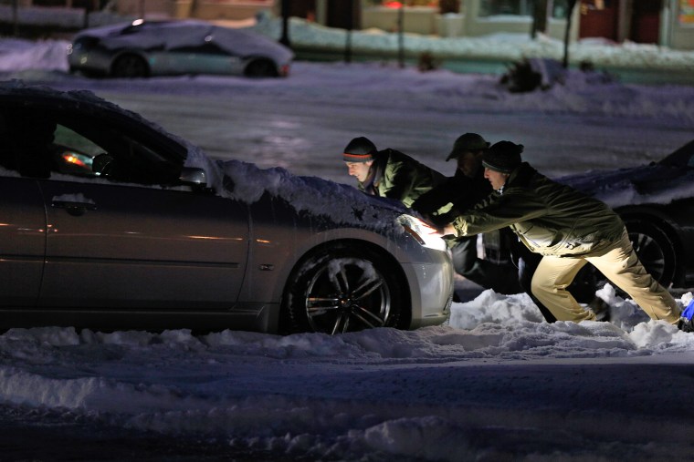 Commuters help dislodge a car stuck on the ice at the Westfield, N.J. train station early Wednesday morning.