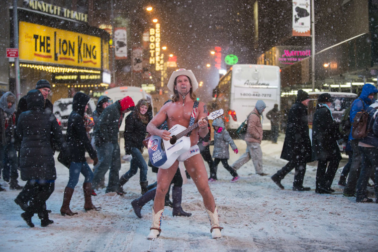 Image: Robert Burck, also known as the original 'Naked Cowboy', performs in a snow storm on the streets of Times Square, New York
