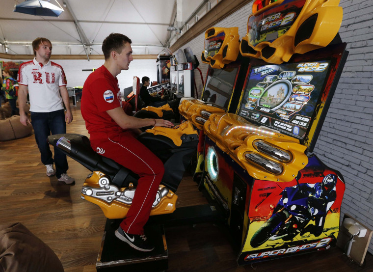 Image: Speed skater Suvorov of Russia plays a video game in the Coastal Athlete's Village in Sochi